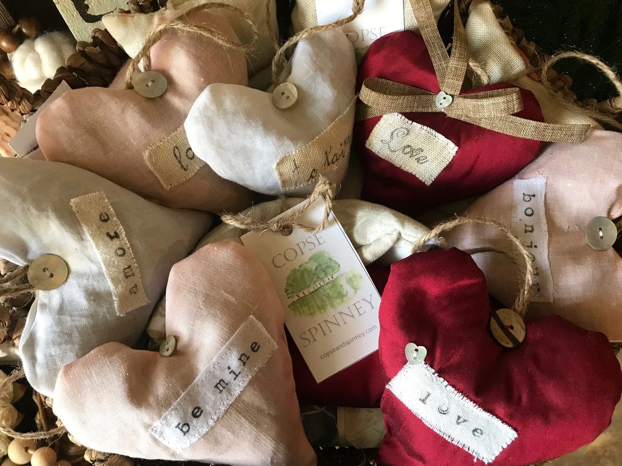 A basket of red silk, and pink or white linen, lavender filled hearts with hand block printed messages for Valentines Day A basket of red silk, and pink or white linen, lavender filled hearts with hand block printed messages for Valentines Day